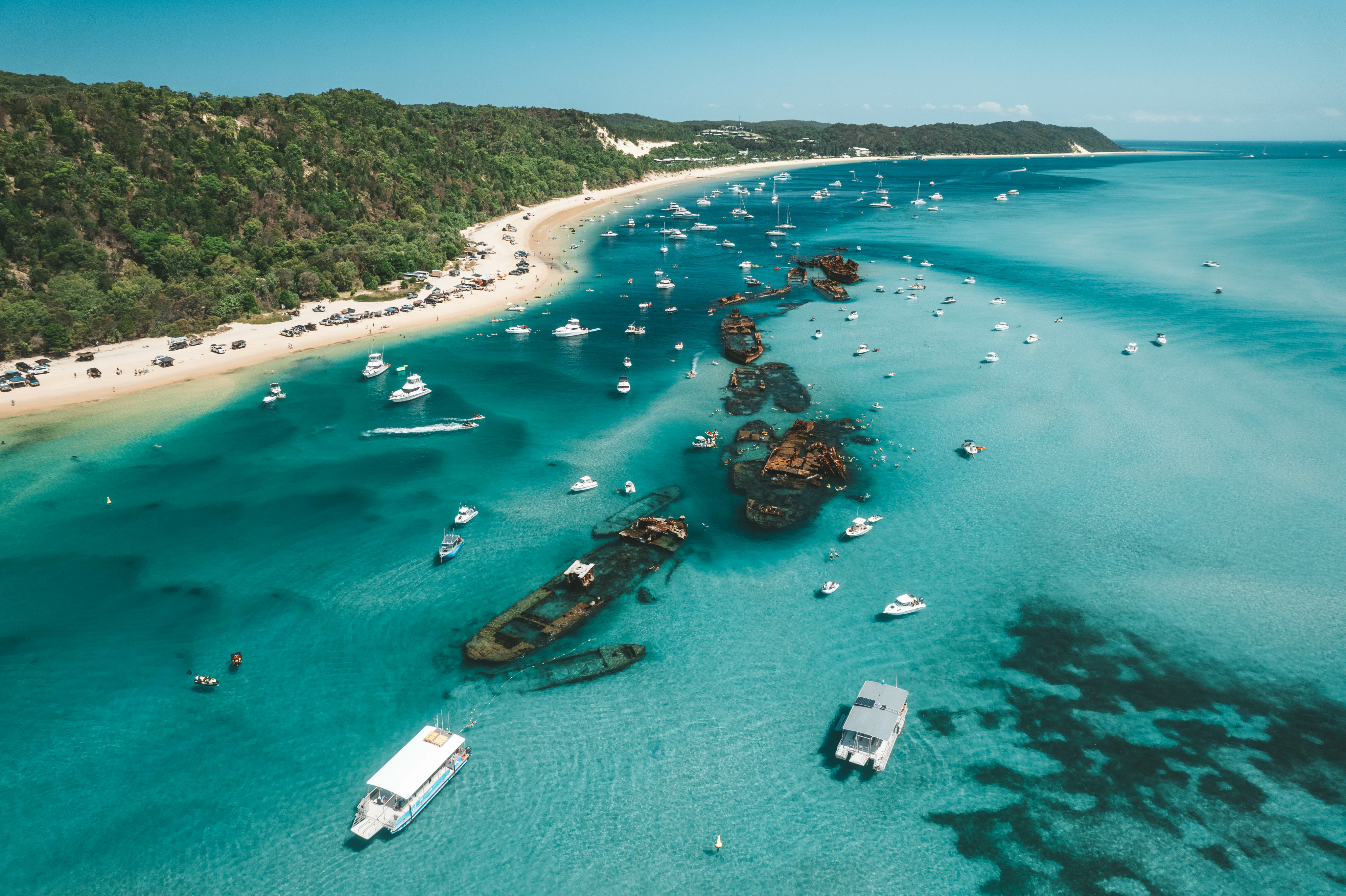 Aerial view of the clear water, beach and boats at Mulgumpin (Moreton Island)