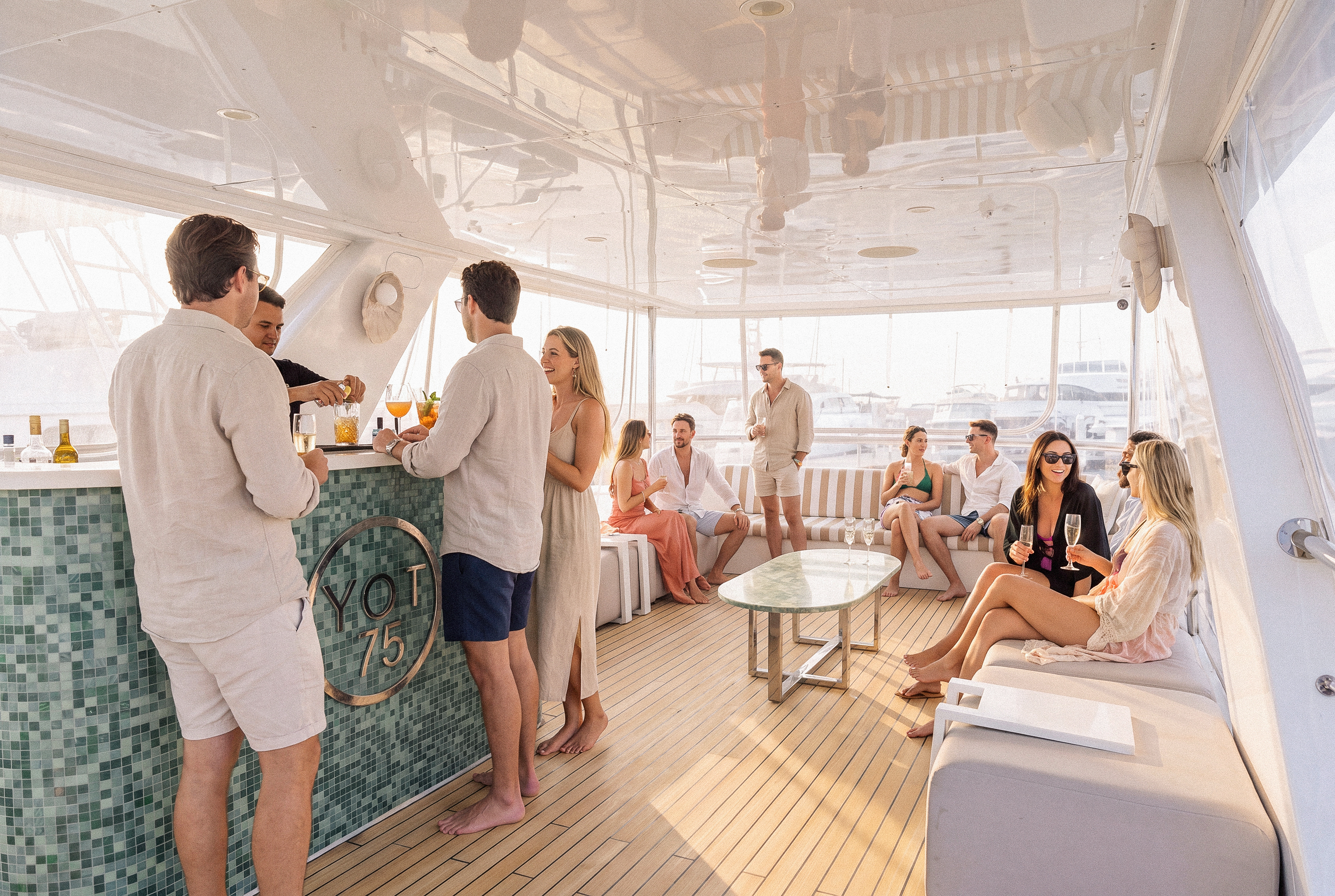 Guests gathering around the upper deck bar aboard YOT 75